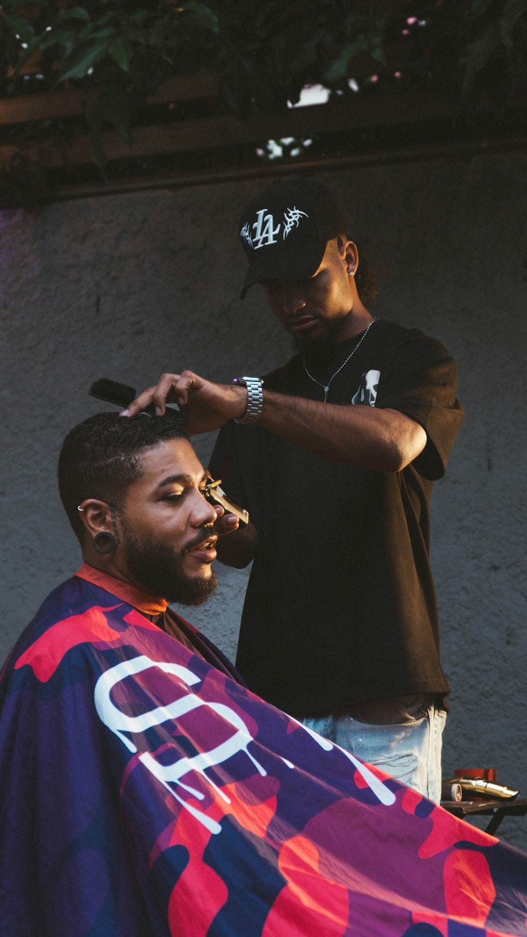 Barber carefully trims client's hair with clippers and comb.